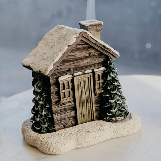 Räucherkegelbrenner im verschneiten Winter der Blockhütte